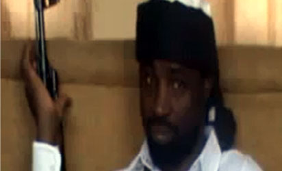 Abubakar Shekau, the leader of Nigeria's Boko Haram Islamist militants, dressed in a black turban and a white gown and bullet-proof vest - holding an AK 47 rifle. In his 40-minute audio message, Shekau reportedly  blamed the deaths of "innocent civilians" on Nigeria's security forces but threatened to carry out a bombing campaign against Nigeria's secondary schools and universities - unless security forces stopped what he claimed was a series of recent attacks on Islamic schools or madrassas in the northern town of Maiduguri.AFP PHOTO / YOUTUBE
