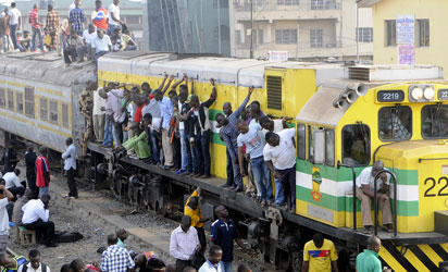 File photo: Passengers hanging on a moving train in Lagos at Ikeja Railway Station, Lagos...