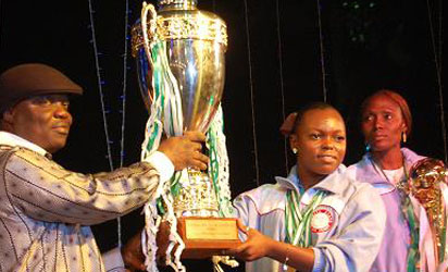 RECEPTION: Team Delta Captain Ruth Izenegu presenting the overall winners trophy to Governor Emmanuel Eweta Uduaghan Tuesday night in Asaba during the reception for the victorious Delta athletes. Uduaghan himself also received an award from Delta State Sports Commission’s Amaju Pinnick for his support for sports in the state.Photo: Henry Unini .