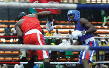Rashidi Fatai of Ogun State (red) and Chinedu Ani of Imo State fight in the boxing 81kg men semi finals bout. Photo: Henry Unini