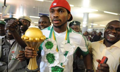 Skipper of Nigerian football team Joseph Yobo (C) holding the Africa Cup of Nations trophy arrives at the airport in Abuja, on February 12, 2013. The newly crowned African champions Nigerian Super Eagles arrives in Abuja to a warm reception by fans and government officials after defeating Burkina Faso to win the 2013 African Cup of Nations in South Africa. AFP PHOTO