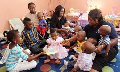 A girl offers her story book during a family visitation to mark Children's Day at the Heritage Orphanage Home, Gwarimpa, Abuja. Photo by Abayomi Adeshida