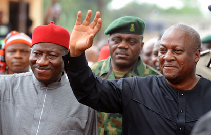 Ghanaian President John Mahama (R) waves to the crowd as he arrives accompanied by Nigerian President Goodluck Jonathan to attend the funeral service for writer Chinua Achebe at Ogidi, Anambra State.AFP PHOTO.