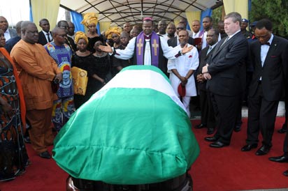 Anglican priest Owen Nwokolo prays in front of the coffin bearing the body of late Nigerian writer Chinua Achebe upon arrival at Abuja airport, on May 21, 2013. The body of Achebe, the author of internationally acclaimed novel "Things Fall Apart" and a towering figure in African literature, arrived in Abuja two months after his death in a US hospital. He is due to be buried in his native town of Ogidi on May 23, 2013. AFP PHOTO/PIUS UTOMI EKPEI