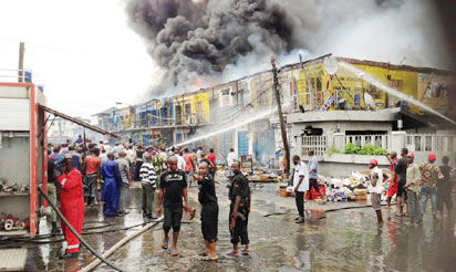 No fewer than 150 shops were razed, yesterday, at the Trinity Spare Parts Market in Ajegunle area of Lagos. Above: The raging fire and rescue operation at the scene.