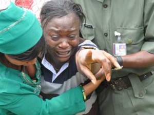 BOKO HARAM VICTIMS—A relation of one of the officers and soldiers killed in Borno, Yobe states and Unamid weeping during their burial at the National Military Cemetery in Abuja, yesterday.Photo: Abayomi Adeshida.