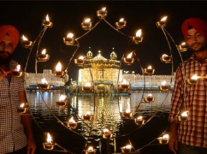 NDIA, Amritsar : Indian Sikh devotees lights candles at the illuminated Sikhism's holiest shrine Golden Temple in Amritsar on November 3, 2013, on the ocassion of Bandi Chhor Divas or Diwali. Sikhs celebrate Bandi Chhor Divas or Diwali to mark the return of the Sixth Guru, Guru Hargobind Ji, who was freed from imprisonment and also managed to release 52 political prisoners at the same time from Gwalior fort by Mughal Emperor Jahangir in 1619. AFP PHOTO