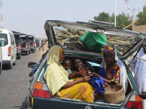 NIGERIA, Maiduguri : Women and children gather into a car's trunk as villagers flee the village of Jakana, outside Maiduguri, Borno State, Nigeria, on March 6, 2014.. AFP PHOTO