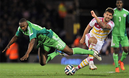 UNITED KINGDOM, London : Nigeria's striker Shola Ameobi (L) vies with Scotland's defender Charlie Mulgrew (R) during the international friendly football match between Nigeria and Scotland at Craven Cottage in London on May 28, 2014, ahead of the FIFA World Cup . AFP PHOTO
