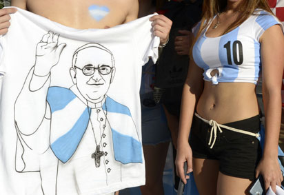Argentinean supporters pose with a t-shirt featuring a picture of Pope Francis outside of the Maracana Stadium in Rio de Janeiro, on June 15, 2014 before the start of the 2014 FIFA World Cup Group F football match between Argentina and Bosnia-Herzegovina. AFP PHOTO / Juan Mabromata