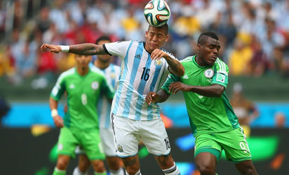 Marcos Rojo of Argentina goes for a header against Emmanuel Emenike of Nigeria during the 2014 FIFA World Cup Brazil Group F match between Nigeria and Argentina at Estadio Beira-Rio on June 25, 2014 in Porto Alegre, Brazil. (FIFA)
