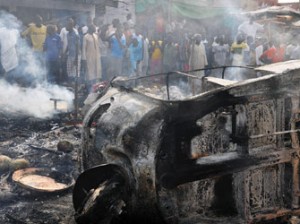 Maiduguri : People gather to look at a burnt vehicle following a bomb explosion that rocked the busiest roundabout near the crowded Monday Market in Maiduguri, Borno State, on July 1, 2014. A truck exploded in a huge fireball killing at least 15 people on July 1 in the northeast Nigerian city of Maiduguri, the latest attack in a city repeatedly hit by Boko Haram Islamists. AFP PHOTO
