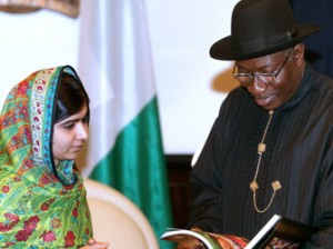 Pakistani education activist Malala Yousafzai (L) watches on July 14, 2014 Nigerian President Goodluck Jonathan look at a book at the State House in Abuja. Malala on July 14 urged Jonathan to meet with parents of the schoolgirls kidnapped three months ago by Boko Haram. Malala, who survived a Taliban assassination attempt in 2012 and has become a champion for access to schooling, was in Abuja on her 17th birthday to mark the somber anniversary of Boko Haram's April 14 abduction of 276 girls from a secondary school in the northeast Nigerian city of Chibok.
AFP PHOTO