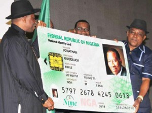 PRESIDENT GOODLUCK JONATHAN (L), DISPLAYING A DUMMY OF HIS NATIONAL IDENTITY CARD AT THE LAUNCH OF e-ID CARD IN ABUJA ON THURSDAY (28/8/14). WITH HIM ARE MINISTER OF AGRICULTURE, DR AKINWUMI ADESINA AND BOARD CHAIRMAN, NATIONAL IDENTITY MANAGEMENT COMMISSION, PRINCE UCHE SECONDUS. BJO/NAN -