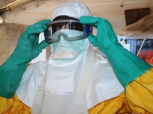 A file photo taken on June 28, 2014 shows a member of Doctors Without Borders (MSF) putting on protective gear at the isolation ward of the Donka Hospital in Conakry, where people infected with the Ebola virus are being treated. Guinea announced on August 9, 2014 it was closing its land borders with Liberia, Sierra Leone over Ebola fears. AFP PHOTO