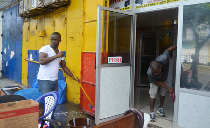 Men clean their shop in Monrovia where offices were closed for disinfection against the epidemic of the haemorrhagic fever Ebola on August 1, 2014. The head of the World Health Organization and presidents of the west African countries suffering the world's worst-ever Ebola outbreak meet in Guinea today to launch a $100 million (75 million euros) emergency joint response plan. AFP PHOTO