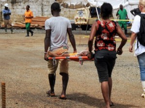 People carry a sick child on a stretcher outside the Elwa hospital run by Medecins Sans Frontieres (Doctors without Borders) in Monrovia on August 30, 2014. Liberia has been hardest-hit by the Ebola virus raging through west Africa, with 624 deaths and 1,082 cases since the start of the year. AFP PHOTO