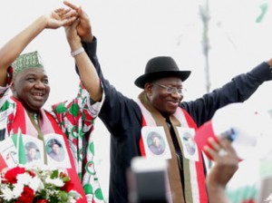 Nigerian President Goodluck Jonathan (R) and Nigerian Vice President Namadi Sambo greet supporters at a ceremony in Abuja on November 11, 2014. Nigeria's President Goodluck Jonathan on November 11 declared his bid for re-election, vowing to finally defeat Boko Haram whose rise in strength during his first term has threatened the country's sovereignty. The 56-year-old made the announcement to tens of thousands of supporters in the red, white and green of his ruling Peoples Democratic Party (PDP), at a carefully orchestrated ceremony including patriotic music, dancing, prayers and speeches. AFP PHOTO