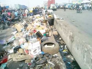 Heap of refuse at Coconut bus-stop on the Oshodi-Apapa expressway, yesterday.