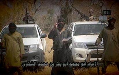 In this screen grab image taken on February 9, 2015 from a video made available by Islamist group Boko Haram, leader Abubakar Shekau (C) makes a statement at an undisclosed location.  Boko Haram leader Abubakar Shekau vowed in a new video released on January 9, 2015 that the group would defeat a regional force fighting the militants in Nigeria's far northeast, Niger and Cameroon."AFP PHOTO / BOKO HARAM" - 