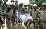 A handout picture from the Nigerian military taken on February 26, 2015 shows troops posing with a flag of Boko Haram after dismantling a Boko Haram camp along Djimitillo Damaturu road, Yobe State in northeastern Nigeria, following fierce fighting that resulted in the capture of machine guns and rifles as well as the death of a number of the insurgents. Boko Haram has vowed to disrupt March 28 elections, which originally were planned for February 28 but rescheduled following security threat. AFP