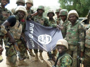 A handout picture from the Nigerian military taken on February 26, 2015 shows troops posing with a flag of Boko Haram after dismantling a Boko Haram camp along Djimitillo Damaturu road, Yobe State in northeastern Nigeria, following fierce fighting that resulted in the capture of machine guns and rifles as well as the death of a number of the insurgents. Boko Haram has vowed to disrupt March 28 elections, which originally were planned for February 28 but rescheduled following security threat. AFP