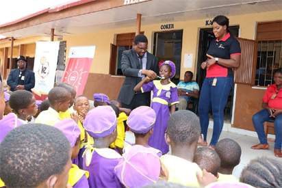L-R Dr. Abolade Majekodunmi of Hygeia HMO demonstrating with a pupil on how to wash teeth during PCSR activities at Coker Primary School Ifako Ijaye and Kenchukwu Okafor of Corporate Communications Ikeja Electric watching the exercise.