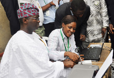 An INEC official Mrs. Seye Soriyan, HOU ICT, INEC Lagos, Assisting Governor Babatunde Fashola, at Word G,3, Idita zone, Itolo Street, Surulere, during the on-going Voters Registration Exercise in Lagos. Photo by Bunmi Azeez