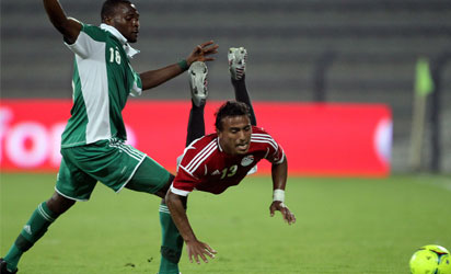 Egypt's Mohammed Abdel Shafi (R) is fouled by Nigeria's Daniel Akpeyi during their friendly football match in the Gulf emirate of Dubai on April 12, 2012. Egypt 3  Nigeria 2. AFP PHOTO