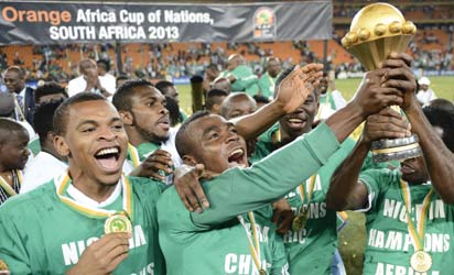 Nigeria's national football team players hold the trophy as they celebrate winning the 2013 African Cup of Nations final against Burkina Faso on February 10, 2013 at Soccer City stadium in Johannesburg. AFP PHOTO