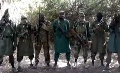 A picture taken from a video distributed to journalists in recent days through intermediaries and obtained by AFP on March 5, 2013 reportedly shows Abubakar Shekau (C), the suspected leader of Nigerian Islamist extremist group Boko Haram, flanked by six armed and hooded fighters in an undisclosed place.