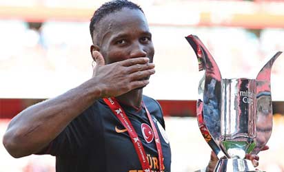 SWEET VICTORY: Drogba with the Emirates Cup Sunday. AFP.