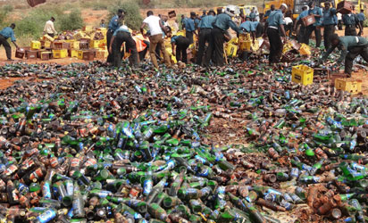 Sharia enforcers called Hisbah destroy thousands of bottles of beer outside northern Nigeria's largest city of Kano on November 27, 2013. The Hisbah destroyed over 240,000 bottles of beer along with over 8,000 litres of local brew called "Burukutu". AFP