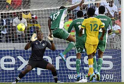 *POINT BLANK.......Super Eagles’ Chinoso Obiozor (C) scores against Zimbabwe’s goalie George Chigova during the third place match of CHAN on February 1. PHOTO: AFP
