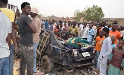 People look at the wreckage of a car, yesterday, after two explosions killed over 35 people in a crowded neighbourhood in Maiduguri, Borno State, weekend. Photo: AFP.