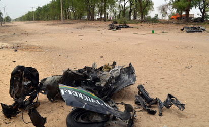 NIGERIA, Maiduguri : A picture shows the wreckage of a police van that was targeted suspected Boko Haram militants in Nigeria's troubled northeastern city of Maiduguri on March 25, 2014, killing five police officers. A vehicle approached the parked van and an explosive was thrown towards it, with the blast killing all the officers inside as well as the three attackers. AFP PHOTO