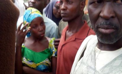 One of the lucky abducted students in Chibok who was later rescued and being handed over by her parents at school premises on Monday. Photo by Ndahi Maiduguri.
