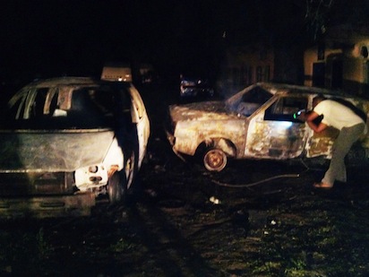 A man checks the wreckage of a car at the scene of a suicide blast at the predominantly Christian Sabon Gari neighbourhood in Kano, northern Nigeria, on May 18, 2014. Five people including the bomber were killed when an explosives-laden car exploded near an open-air beer garden, destroying six cars and shattering windows of several buildings. AFP PHOTO