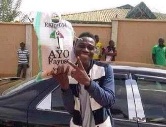 An Ekiti State University student displaying a bag of rice he got from Ayo Fayose