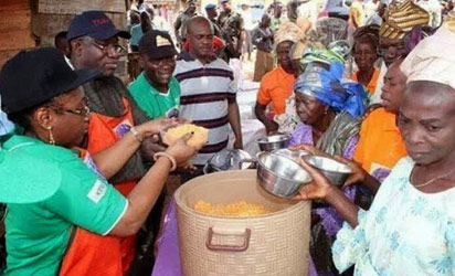 Governor Fayemi and his wife sharing cooked jollof rice to elderly people in the state