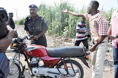 A Policeman seizing a motorcycle from the owner, in Lagos.