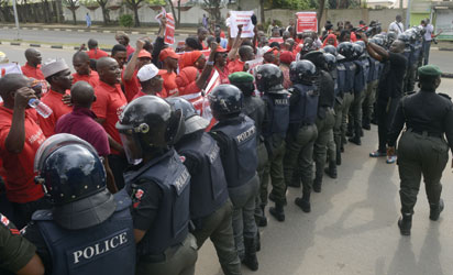 File: Policewomen block supporters of the #BringBackOurGirls campaign, who ask for the release of the 219 Chibok schoolgirls kidnapped by Boko Haram militants, from marching to the president's official residence in the Nigerian capital Abuja on October 14, 2014.  Nigerian police on Tuesday blocked supporters of 219 schoolgirls kidnapped by Boko Haram militants from marching on the president's official residence on the six-month anniversary of the abduction. A wall of female officers in full riot gear formed the first line of a barricade in front of less than 100 members of the Bring Back Our Girls campaign, preventing them from setting out. AFP PHOTO