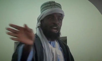 A screengrab taken on November 9, 2014 from a new Boko Haram video released by the Nigerian Islamist extremist group Boko Haram and obtained by AFP shows the leader of the Nigerian Islamist extremist group Boko Haram, Abubakar Shekau preaching to locals in an unidentified town. Shekau again dismisses government claims about ceasefire talks and threatens to kill the man who has presented himself as Boko Haram’s negotiator.  AFP PHOTO 