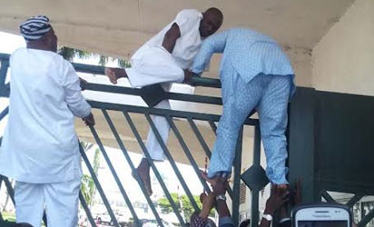 Police attack at National Assembly: Lawmakers scaling gate of National Assembly as Police blocked National Assembly gate in Abuja. Photo by Gbemiga Olamikan 