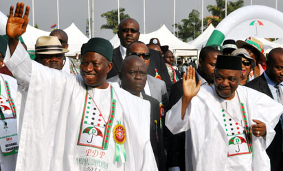 Nigeria's president Goodluck Jonathan (L) and vice president Namadi Sambo wave to supporters during a presidential primary in Abuja, on December 10, 2014. Jonathan is expected to be formally endorsed as the PDP candidate, with no other challengers, for the next year presidential elections. AFP PHOTO
