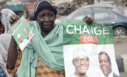 A mother carries banner to drum support for the leading opposition All Progressives Congress presidential candidate Mohammadu Buhari and running mate Yemi Osinbajo during a rally christened 'Walk for Change" in Lagos, on March 7, 2015 in Lagos, Nigeria's commercial capital.   Presidential elections scheduled for February 14 were delayed for six weeks as the military said the ongoing counter-offensive against Islamists Boko Haram meant that troops could not provide security on polling day. AFP PHOTO