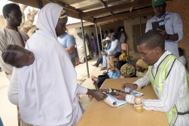 A mother thumb prints her finger to be accredited to vote at a polling station in Daura, Katsina State, during presidential elections on March 28, 2015. Voting in Nigeria's general election has been extended to March 29 in 300 out of 150,000 polling stations, the electoral commission said, after technical glitches marred polling nationwide. AFP PHOTO