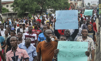 All Progressives Congress (APC) party supporters march towards the Independent National Electoral Commission Office in Port Harcourt during a demonstration calling for the cancellation of the Presidential elections in the Rivers State on March 29, 2015. Nigeria's closely fought general election went into a second day after failures in controversial new technology snarled the polling, including for President Goodluck Jonathan. AFP PHOTO