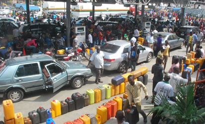 FILE: THE AGONY CONTINUES —The crowd and long queues of jerry cans at Capital Oil filling station, along Lagos-Ibadan Expressway, yesterday. Below right: Stranded commuters' option B in Lagos, also yesterday. Photos:Lamidi Bamidele with NAN.