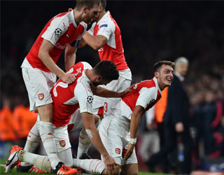 Arsenal's German midfielder Mesut Ozil celebrates scoring his team's second goal during the UEFA Champions League football match between Arsenal and Bayern Munich at the Emirates Stadium in London, on October 20, 2015. Arsenal won the match 2-0. AFP PHOTO